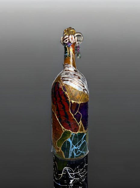 A bottle of wine with colorful glass on top.