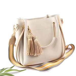 A white purse with gold accents and a strap.