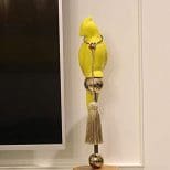 A yellow bird statue on top of a wooden stand.
