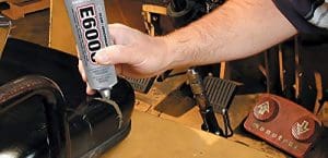 A person using a glue gun to fix the seat of a car.