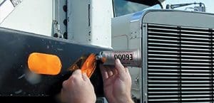 A person is working on the side of a truck.