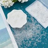 A table with some white sand and flowers