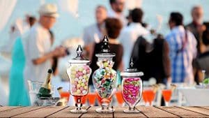 Three glass jars filled with candy on top of a table.