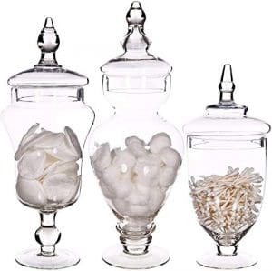 Three glass jars with lids filled with candy.