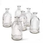 A group of six glass bottles on top of each other.