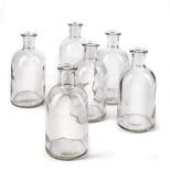 A group of six glass bottles on top of each other.