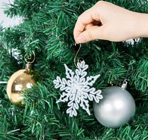 A person holding onto a christmas ornament
