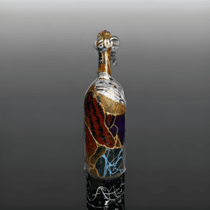 A bottle of wine with colorful glass on top.