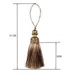 A gold and brown tassel hanging from a metal pole.