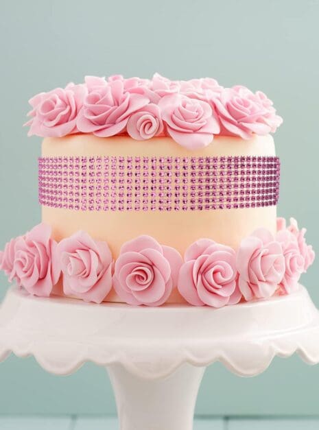 71Ic6VK5zHS._AC_SL1500_ A cake with pink roses on top of it.