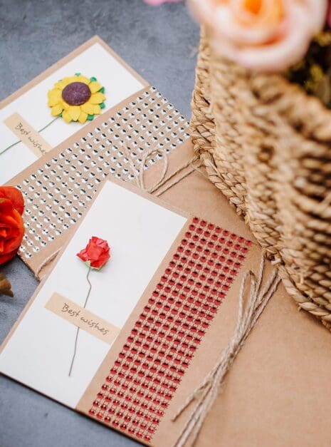 810vDMnEgqS._AC_SL1500_ A basket of flowers and two cards on the table.