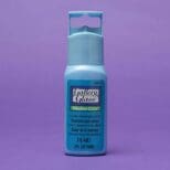 A bottle of blue paint on a purple background.