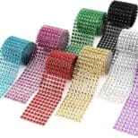 A group of different colored rolls of rhinestone ribbon.