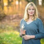 A woman holding a glass of beer in her hand.