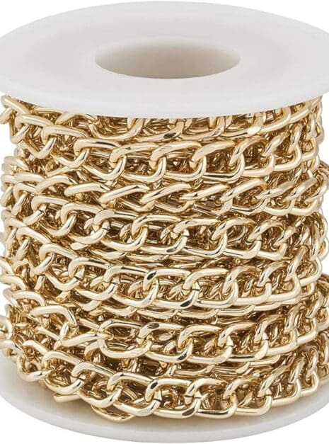 A spool of gold chain on top of white plastic.