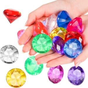 Hands holding a collection of colorful, transparent acrylic gemstones 1.5” in various shapes and sizes.