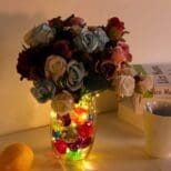 A vase filled with colorful rocks and flowers.