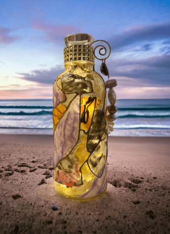 A glass bottle with lights on the beach