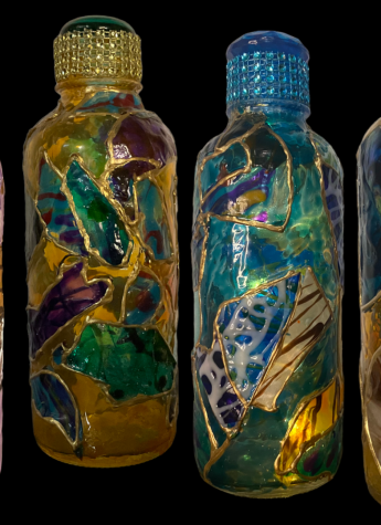 Four glass bottles with different designs on them.